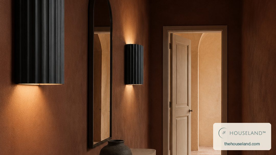 a half-cylinder fluted resin wall sconce in dark charcoal, ribbed vertically, throwing light up and down the wall in two a pair along the vestibule wall, the nearest one large in the foreground