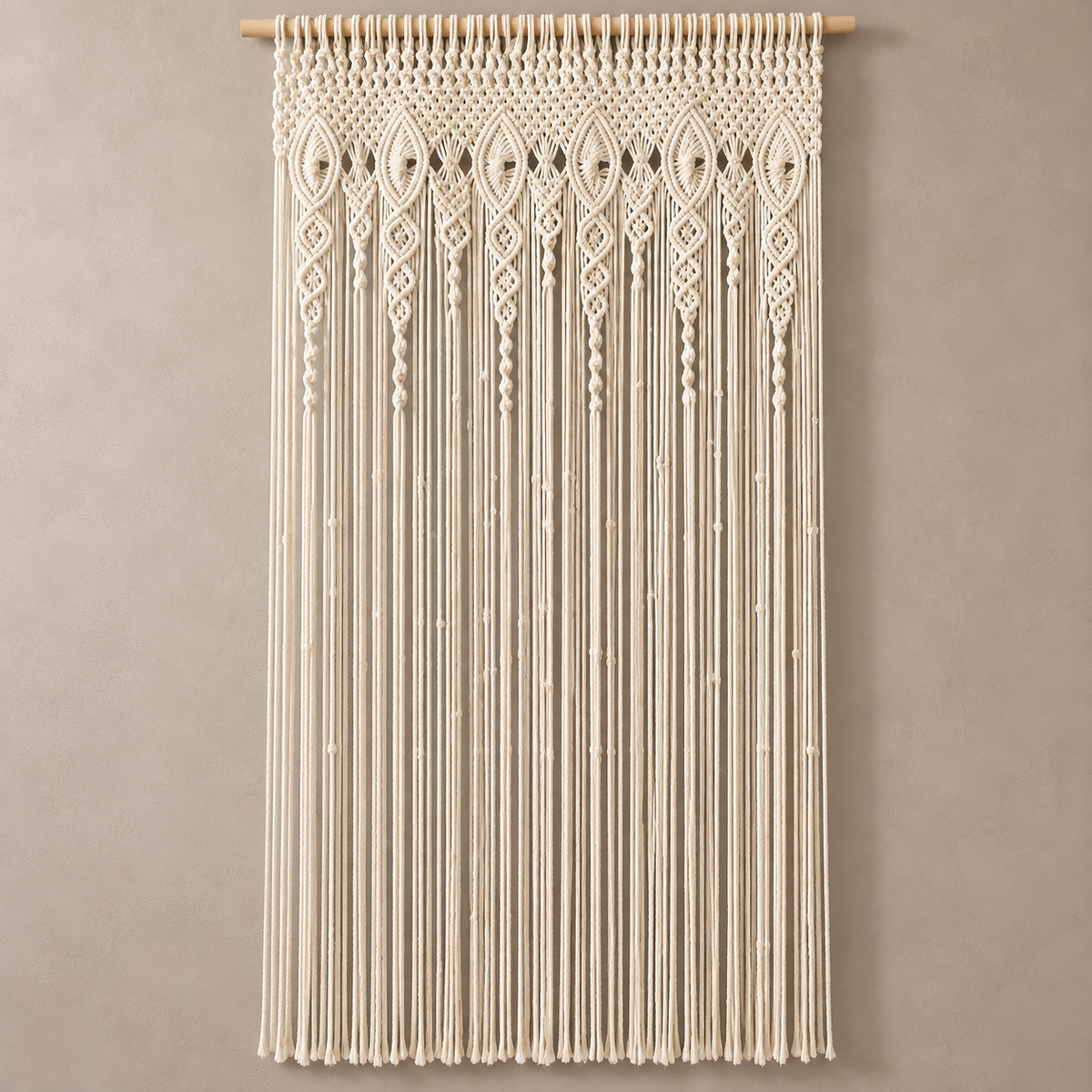 Full length cream macrame door curtain against a warm gray studio wall