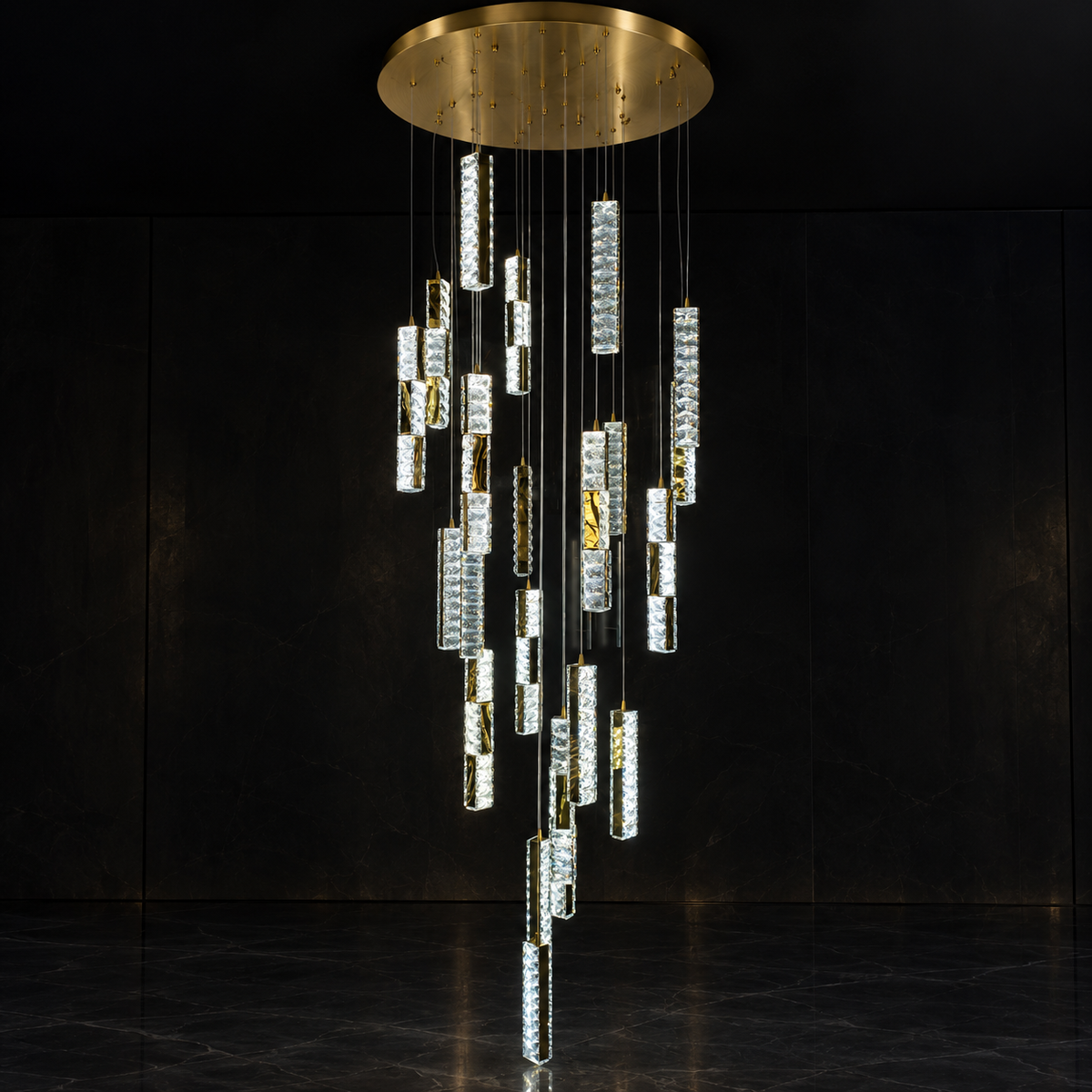 A modern multi-light chandelier with a circular brushed gold ceiling canopy and multiple cascading clear cylindrical crystal prisms, shown against a dark black background.