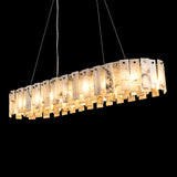 Linear pendant light with layered alabaster panels glowing warm yellow against a black background.