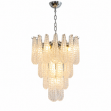A modern multi-tier chandelier with textured, ribbed glass shades in a warm cream color, suspended from a polished silver-toned metal chain and ceiling canopy against a plain white background.