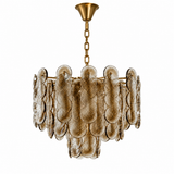A tiered chandelier with textured, overlapping circular glass shades in a warm gold finish, suspended by a gold chain from a matching gold ceiling canopy, shown against a solid white background.