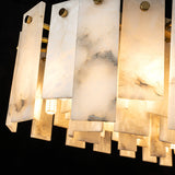 Pendant light close-up showing gray veining in white alabaster panels, round gold fasteners, and warm light against a black background.