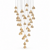 A modern multi-light pendant chandelier with multiple teardrop-shaped clear glass droplets featuring a gold crackle or textured finish, suspended from thin cables in a cascading, V-shaped arrangement against a solid white background.