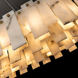Angled close-up of the pendant light showing overlapping alabaster panels, gray veining, gold fasteners, and warm illumination.