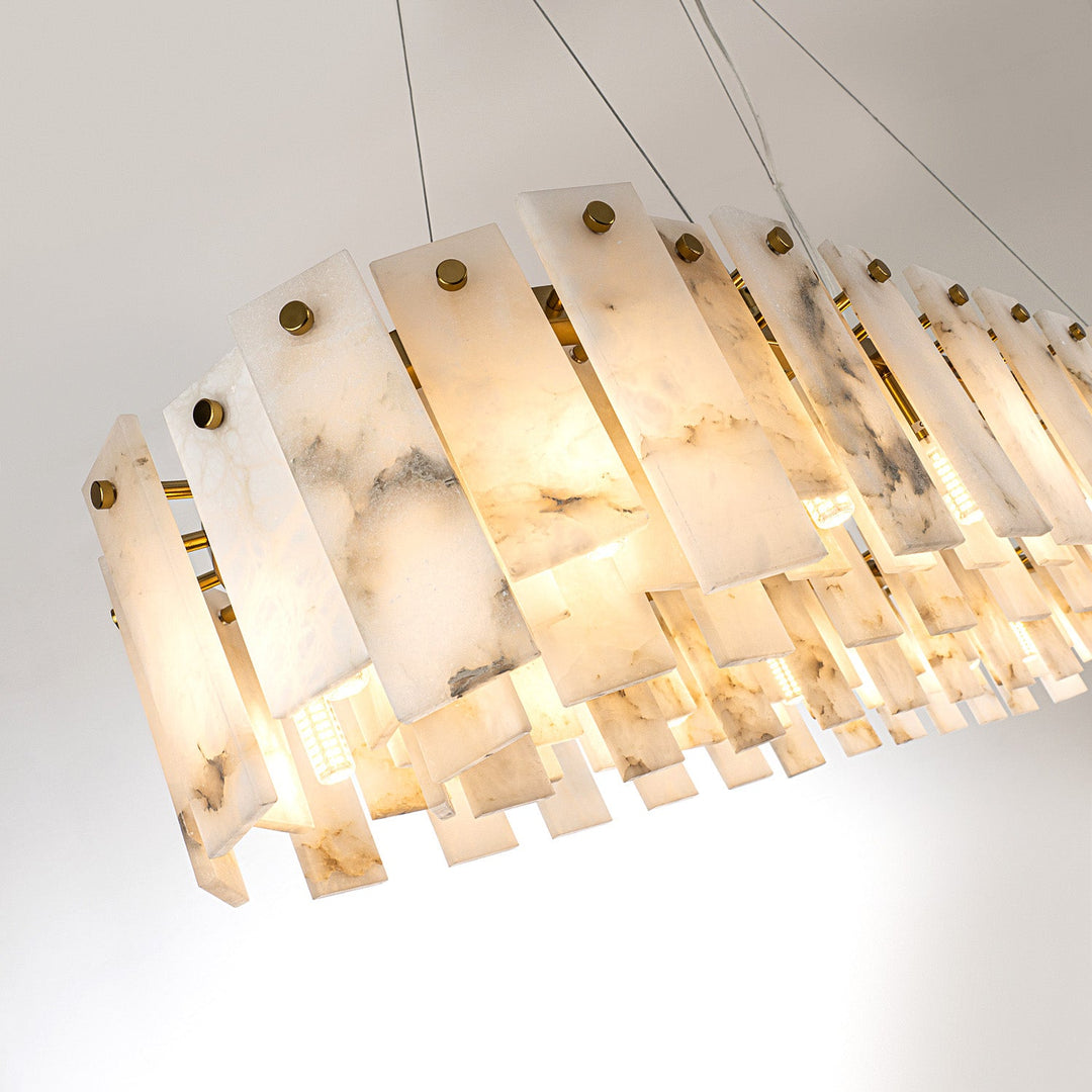 Linear pendant light with overlapping alabaster panels and thin suspension cables, viewed diagonally against a pale background.