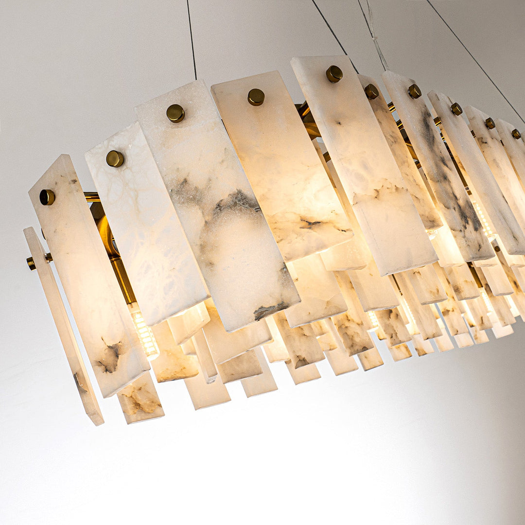 Pendant light with staggered cream alabaster panels, gray veining and round gold-colored fasteners against a pale background.