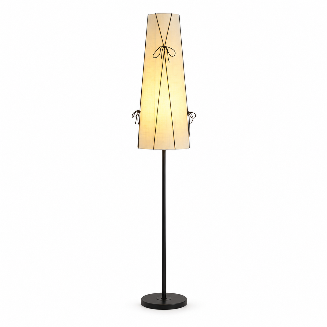 A modern floor lamp with a tapered beige fabric shade, black metal frame details, and a black stand base, shown against a plain white background.