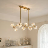 A modern multi-light chandelier with a gold-finished frame and clear crystal flower-shaped bulbs, hanging from the ceiling in a bright, neutral-toned dining or living room.