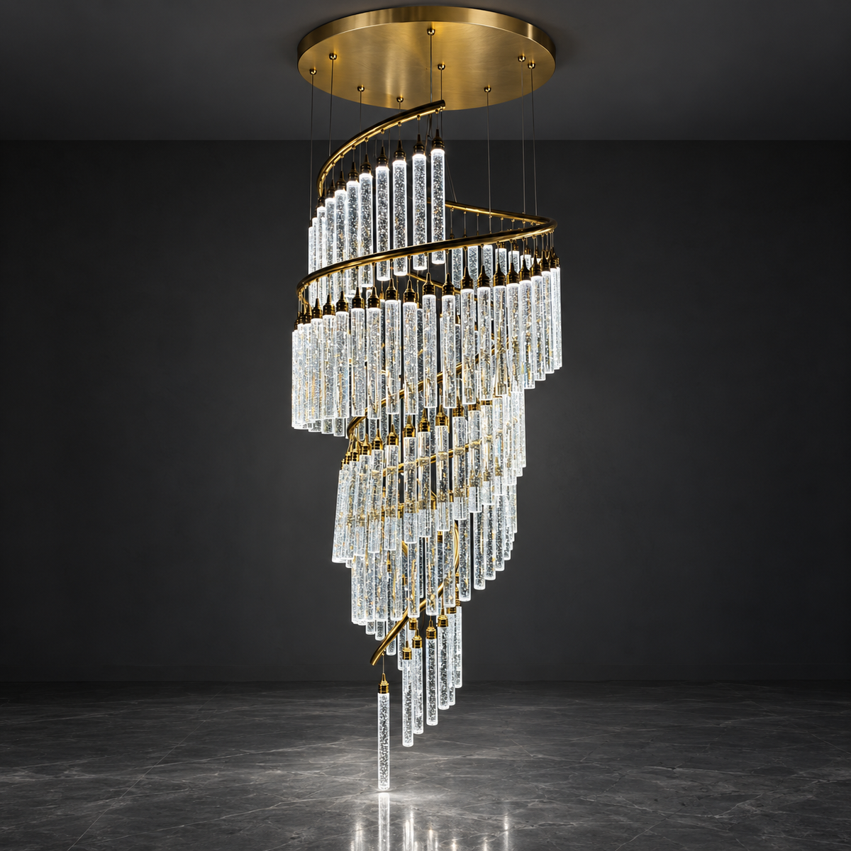 A modern spiral chandelier with clear crystal drop tubes and gold metal accents, suspended from a circular gold ceiling canopy in a dark gray room.