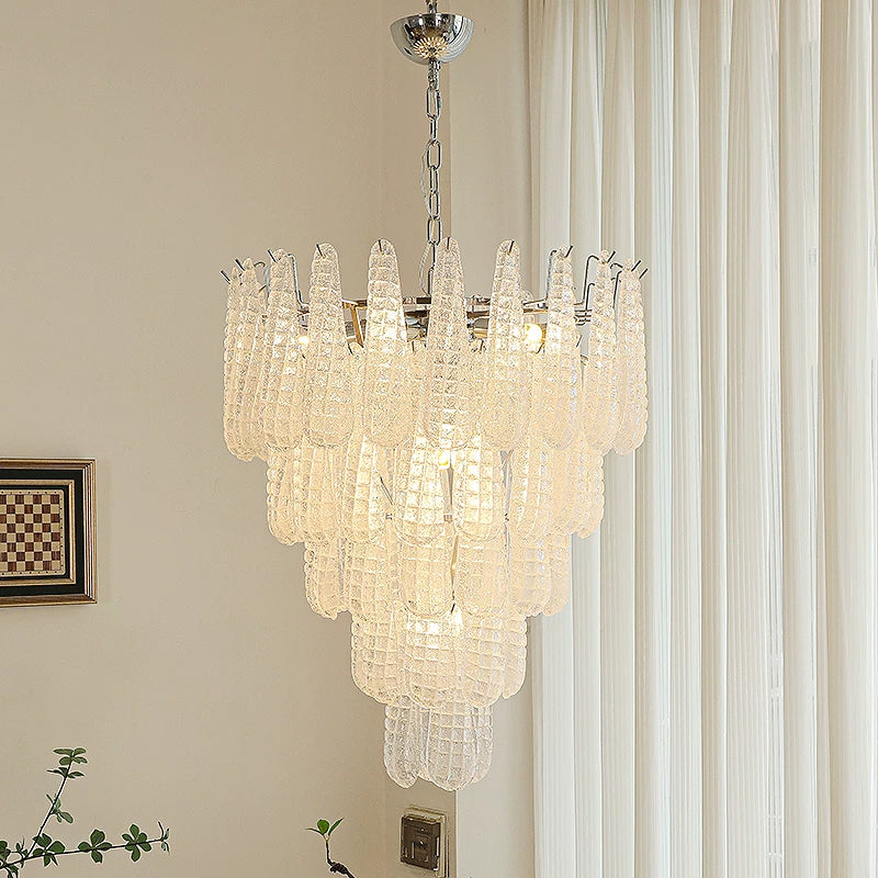 Chandelier hanging in a room with curtains and a wall art piece.
