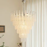 Chandelier hanging in a room with curtains and a wall art piece.