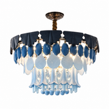 A modern chandelier light fixture featuring a circular arrangement of dark blue and light blue glass teardrop pendants, clear textured glass drops, and a bronze-toned metal ceiling canopy and rod, shown against a plain white background.