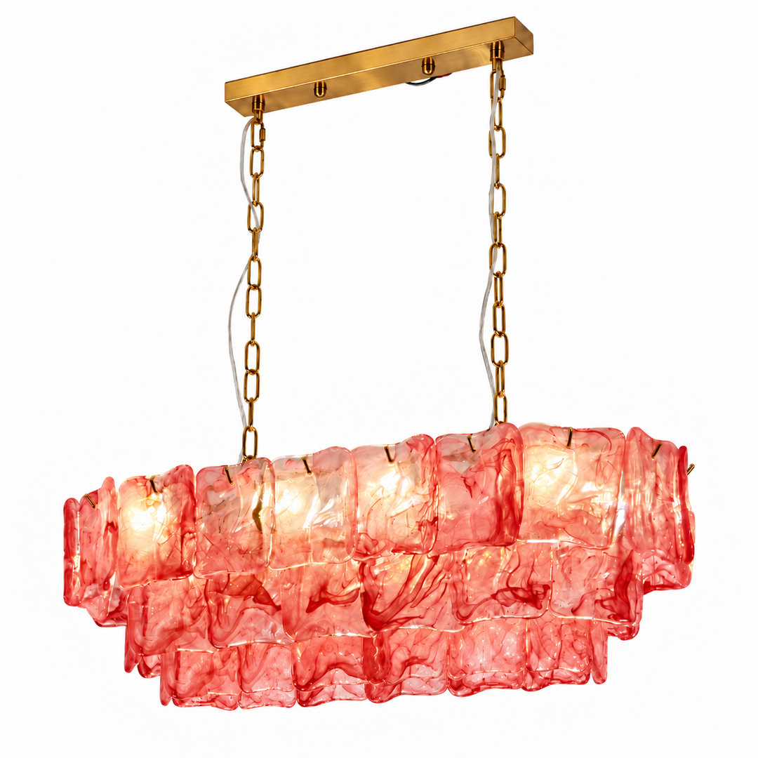 Linear chandelier with three tiers of pink-red textured glass and gold-tone suspension chains against a white background.