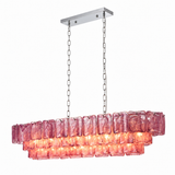 Angled view of a linear chandelier with three tiers of rippled pink-purple glass panels and silver-tone suspension chains against white.