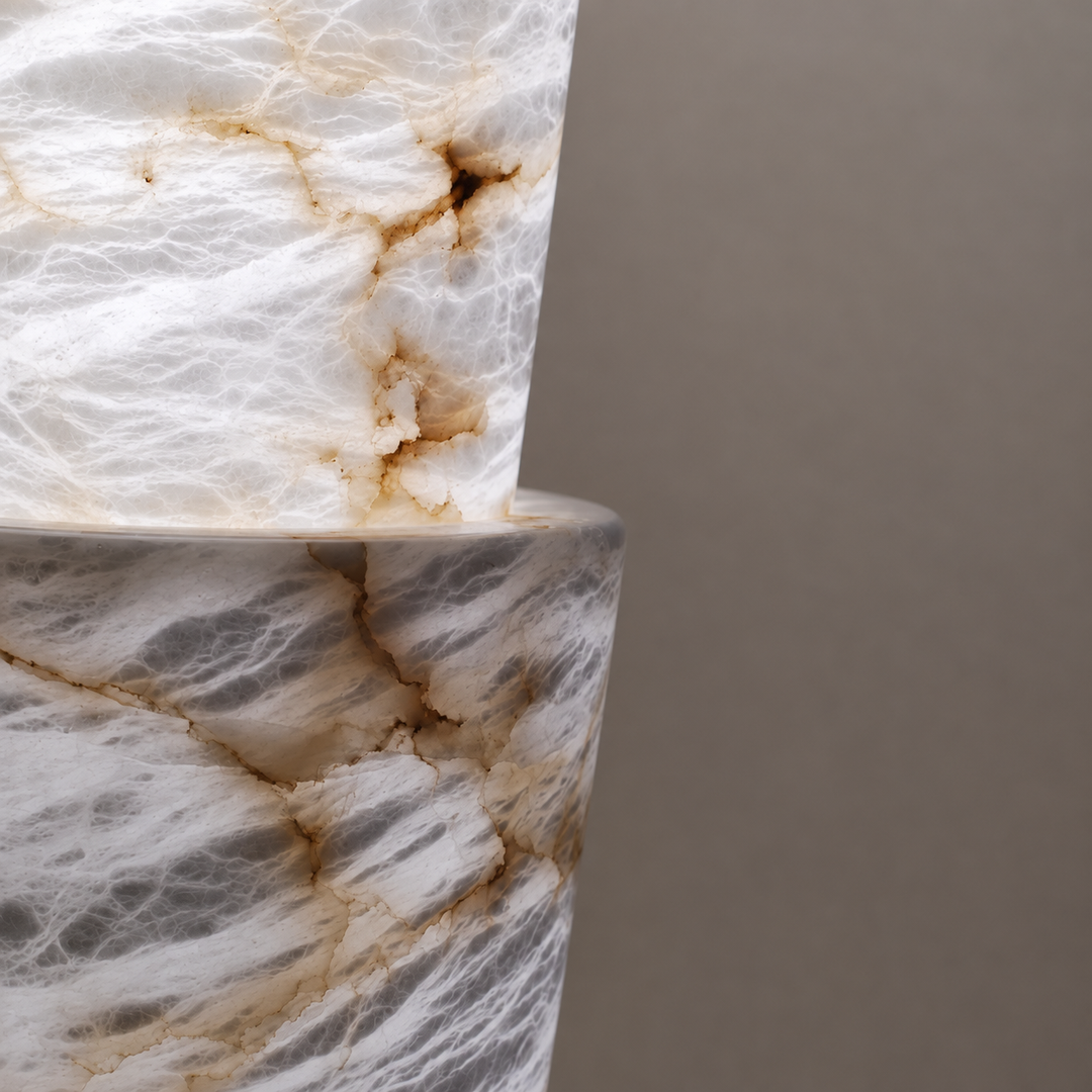 Close-up of the floor lamp’s stacked alabaster sections shows white and gray stone with brown veining against a gray background.