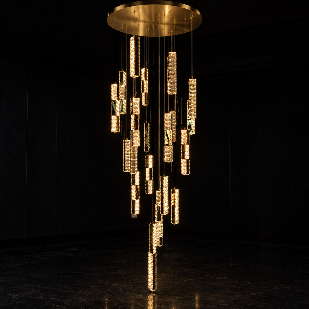 A modern multi-tier chandelier with a circular gold ceiling canopy, featuring numerous vertical crystal-encrusted tubes in varying lengths that dangle in a cascading arrangement against a dark background.