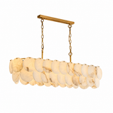 Brass linear chandelier with overlapping cream alabaster discs and two suspension chains against a white background.