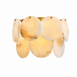 Wall sconce with overlapping cream alabaster discs and brass fittings, glowing warmly against a white background.
