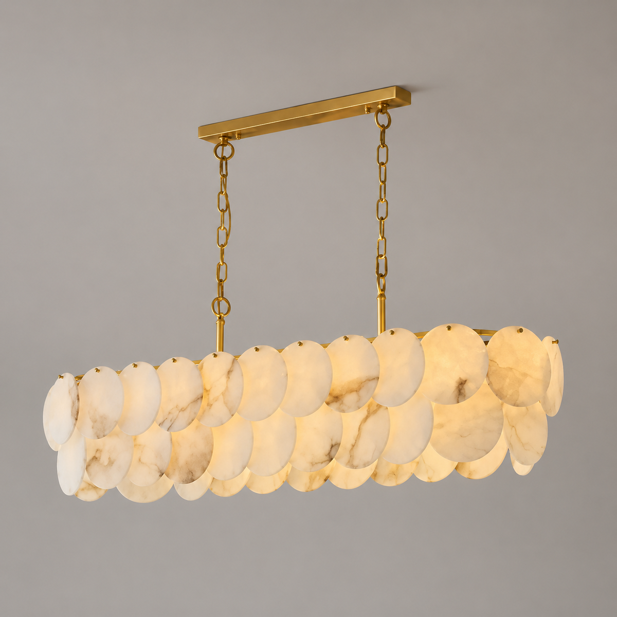 Illuminated linear chandelier with veined alabaster discs and brass suspension chains against a grey background.