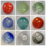 Chandelier glass globes in a nine-panel collage showing red, green, blue, teal, clear and smoky finishes against pale backgrounds.