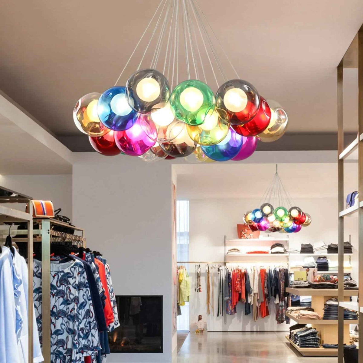 A modern multi-light chandelier with numerous colorful, reflective glass globes suspended from a central point, hanging in a retail store interior.