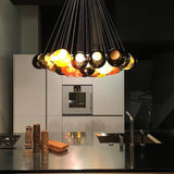 Modern kitchen with a chandelier hanging above a countertop.
