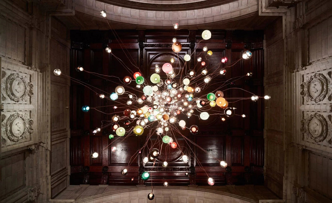 Colorful chandelier hanging in a grand room with wooden paneling