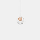 Single-globe chandelier with clear glass surrounding a peach-colored inner sphere, suspended from a thin cord against a white background.