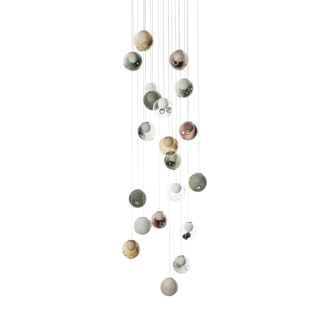 Chandelier with glass globes in muted green, amber, pink, gray, and clear finishes cascading vertically against a white background.