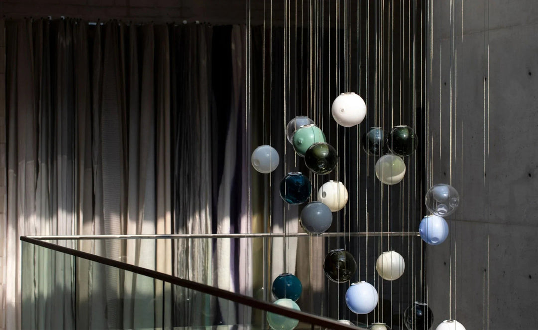 Modern chandelier with colorful glass balls hanging from a staircase.