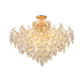 Gold-tone chandelier with curved arms and tiers of clear teardrop pendants, illuminated against a white background.