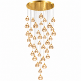 A modern multi-light chandelier with a brushed gold circular ceiling canopy and multiple clear faceted glass pendant globes hanging in a cascading arrangement against a white background.
