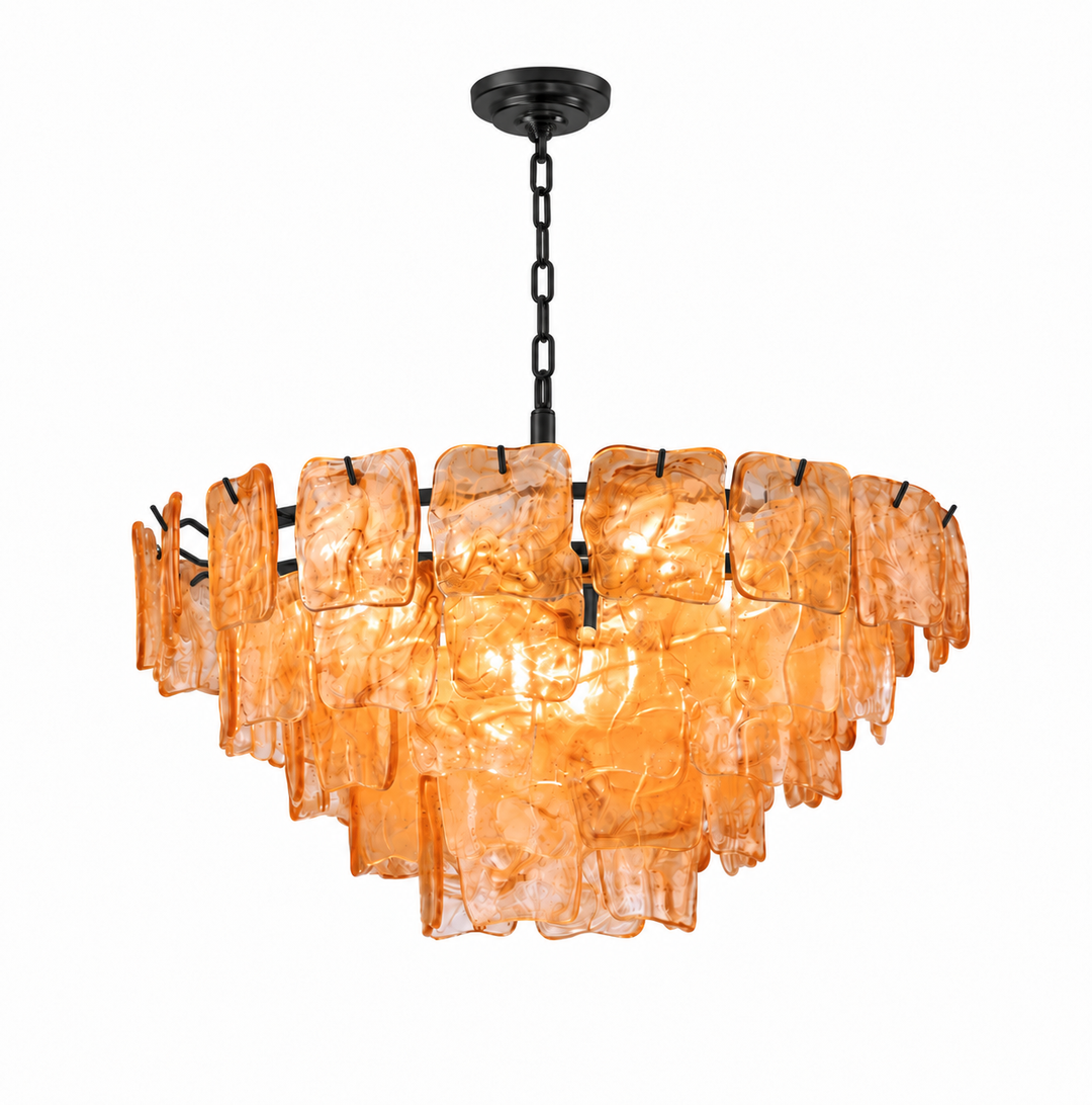 A modern tiered chandelier with a dark metal frame and hanging chain, featuring multiple overlapping translucent amber-orange glass panels that glow when lit, shown against a plain white background.
