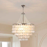 A multi-tiered crystal chandelier with a silver-toned metal frame and hanging glass beads, illuminated in a warm light, shown hanging from a ceiling in an elegant interior room.