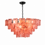 A modern multi-light linear chandelier with textured, irregularly shaped coral-pink glass shades and a black metal canopy, chain, and bar, shown against a solid white background.