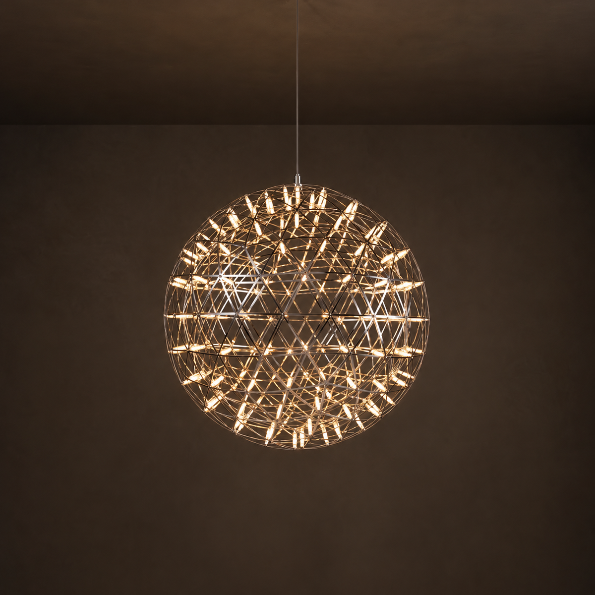 Globe pendant light with an open geometric metal frame and warm glowing tubes hangs against a dark brown background.