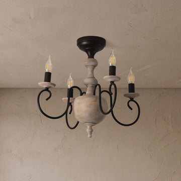 A rustic five-light chandelier with a distressed off-white wood central body and black metal scroll arms, shown hanging from a textured beige ceiling.