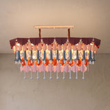 Illuminated rectangular chandelier with layered purple, pink, blue, orange, and clear hanging ornaments against a textured beige background.