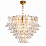 A tiered chandelier with multiple layers of fluted clear glass shades and a brushed gold metal frame, hanging from a matching gold ceiling canopy and chain against a plain white background.