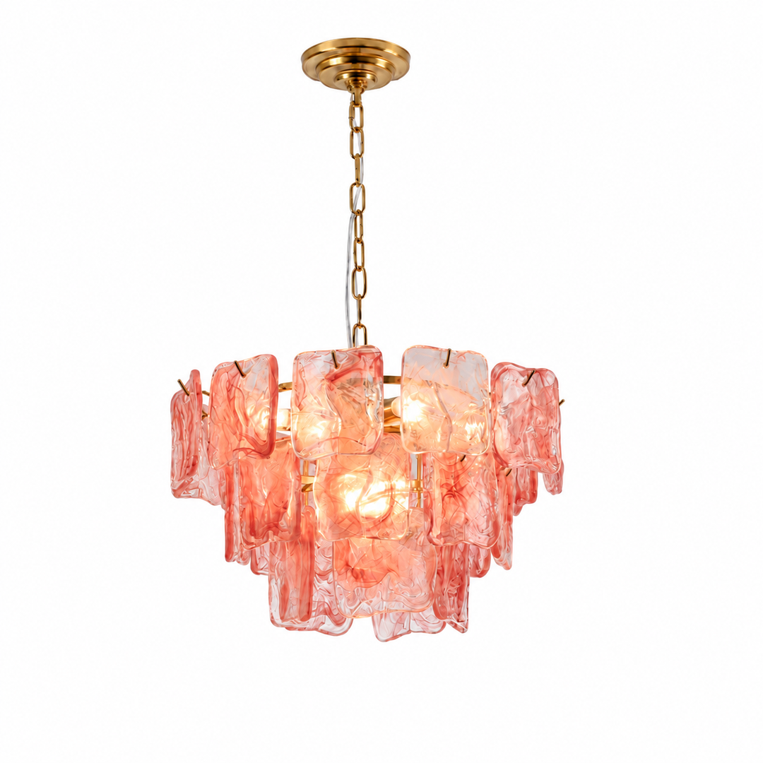 A modern multi-light pendant chandelier featuring textured, translucent pink glass blocks suspended from a gold-finished metal frame and chain.
