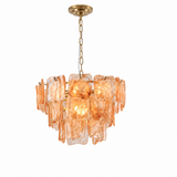 A modern chandelier featuring irregular, wavy amber-orange glass shades suspended from a gold-toned brass canopy and chain.