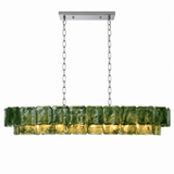 Linear chandelier with two tiers of rippled green glass panels and silver-tone suspension chains, illuminated against a white background.