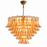 A tiered chandelier featuring multiple layers of fluted, ruffled amber glass shades, suspended from a matching gold-toned chain and ceiling canopy against a plain white background.