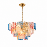 A modern multi-light chandelier featuring multiple rectangular glass shades in translucent amber, pink, blue, and white, suspended from a gold-toned chain and ceiling canopy against a solid white background.