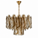 A modern chandelier featuring textured, petal-like smoked glass shades suspended from a gold-toned brass frame and chain, shown against a plain white background.