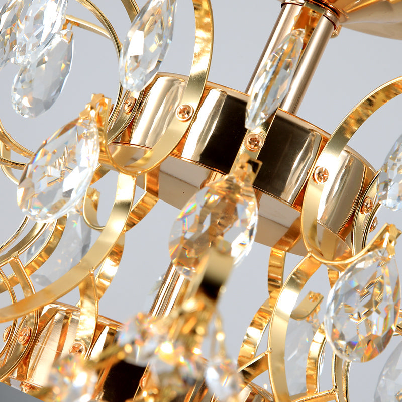 Close-up of a gold chandelier with crystal elements on a gray background