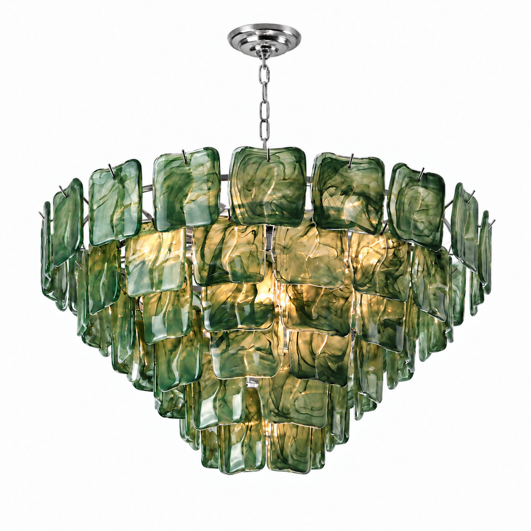 A modern multi-tier chandelier featuring textured green and amber glass panels suspended in a circular arrangement, with a polished silver metal chain and ceiling canopy, shown against a plain white background.
