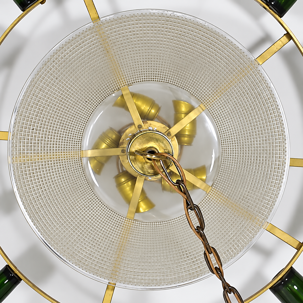 Top-down chandelier detail showing a clear textured glass bowl, brass-toned supports and hanging chain against a white background.