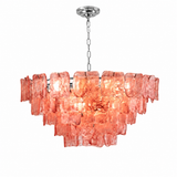 A modern multi-tier chandelier with a brushed silver metal frame and chain, featuring textured, translucent coral-pink glass shades that glow with warm light, set against a plain white background.